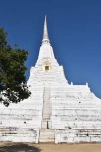 Templo muy alto en forma triangular con una gran escalinata. Chica de pie en la escalinata. Todo el templo es blanco a excepción de una puerta al final de la escalinata que es dorada.