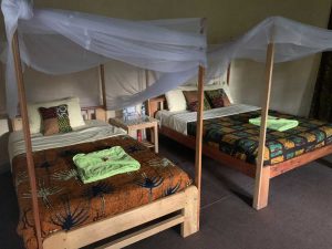 Habitación grande con dos camas y mosquiteras.