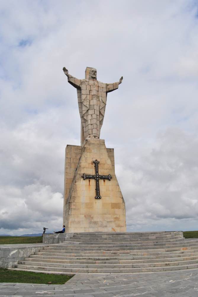 Gran monumento con un pedestal y una cruz y, encima, Jesús con los brazos abiertos
