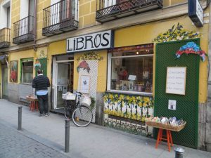 Madrid en 3 días: librería en Malasaña con fachada de color amarillo y una bicicleta en la puerta. En el cartel de la entrada pone 'Libros'.