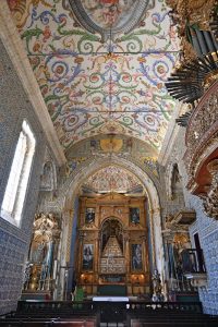 Capilla con paredes revestidas de azulejos. El techo también decorado con formas circulares. Al fondo, un retablo de estilo manierista.
